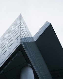 A panoramic view of a high-rise building featuring large modern glass panels with black accents.