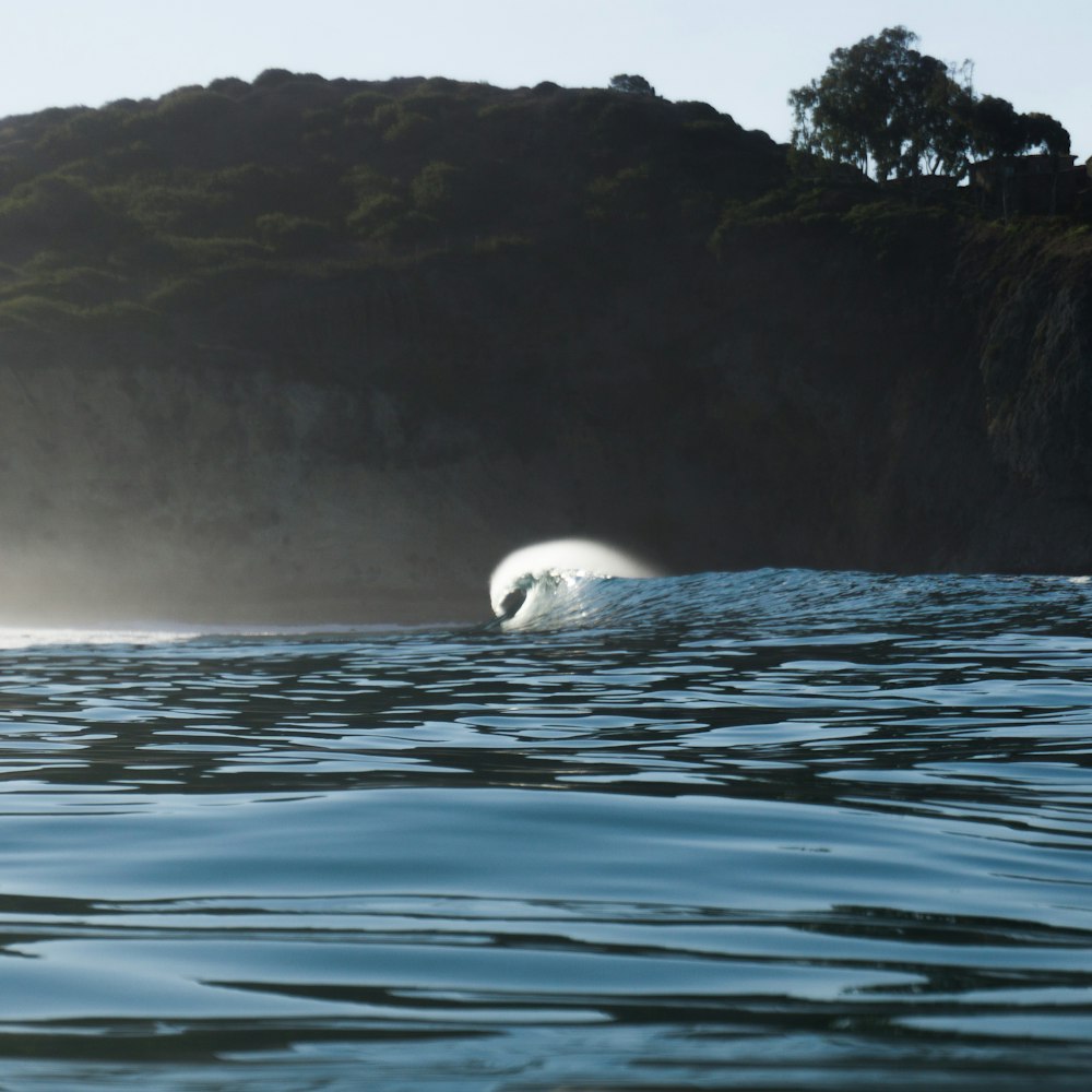 a large white wave in the middle of a body of water