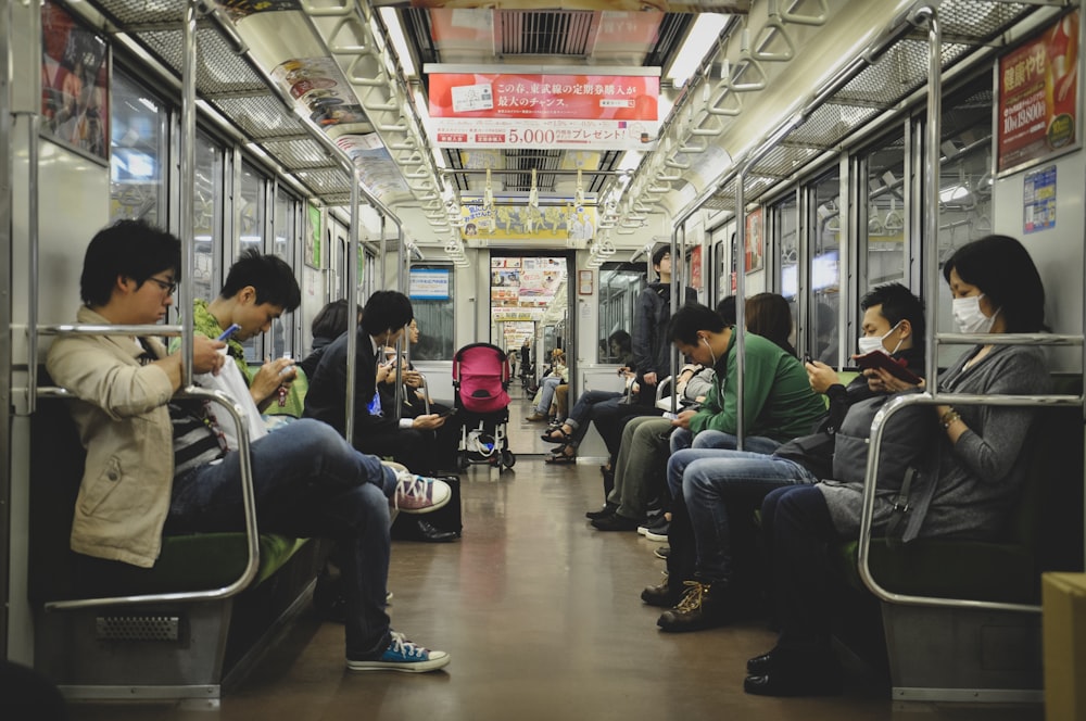 a group of people sitting on a subway train