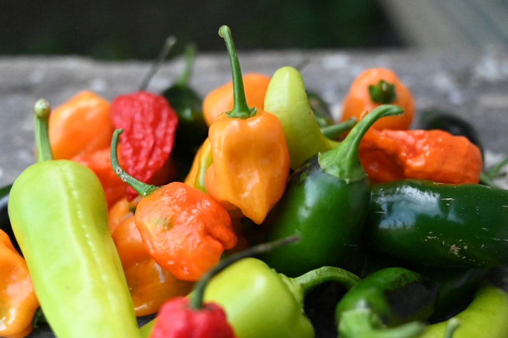 a pile of peppers sitting on top of a wooden table