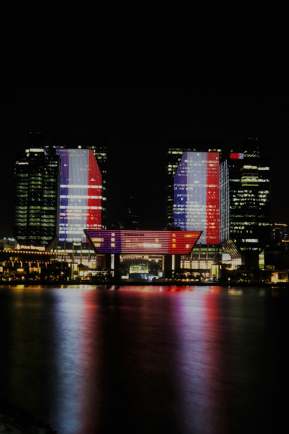 a large body of water in front of a city at night