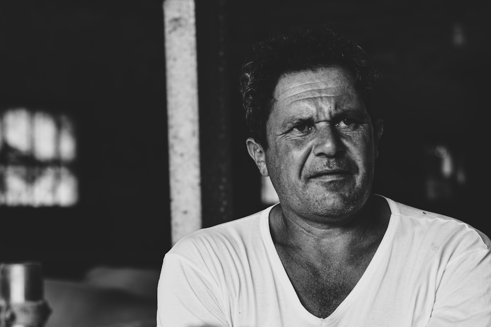 a black and white photo of a man in a white shirt