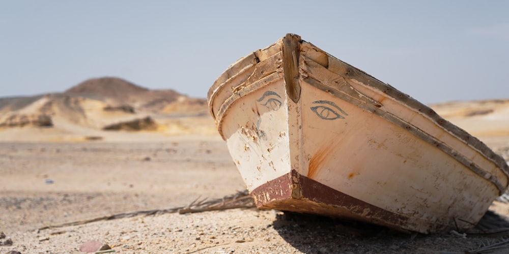 a boat sitting on top of a sandy beach