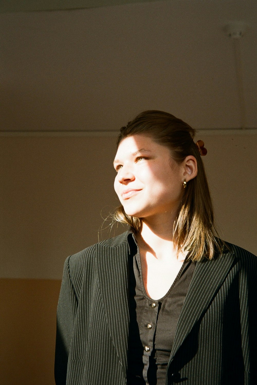 a woman in a suit and tie standing in a room