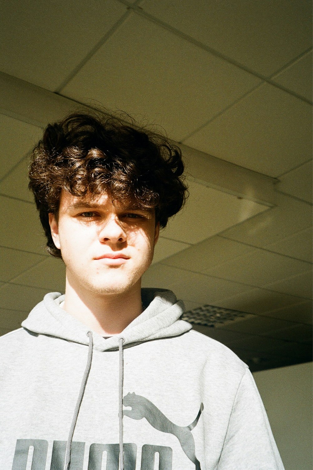 a young man with curly hair wearing a sweatshirt