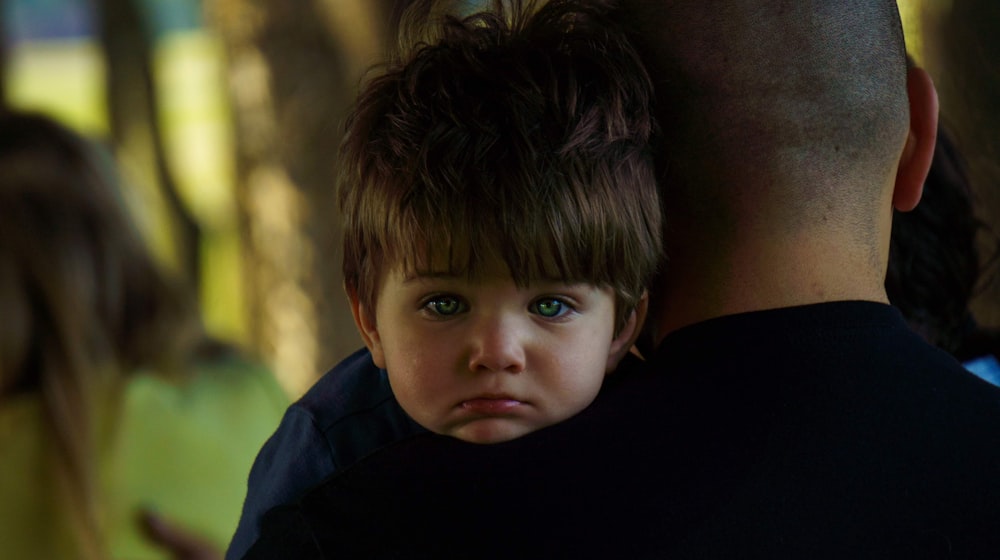 a man holding a little boy in his arms