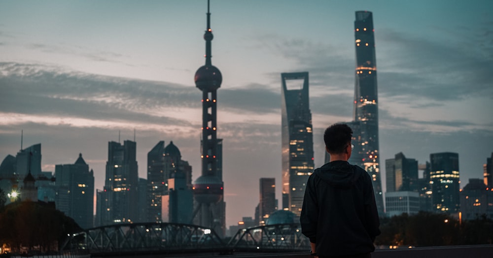 a man standing in front of a city skyline