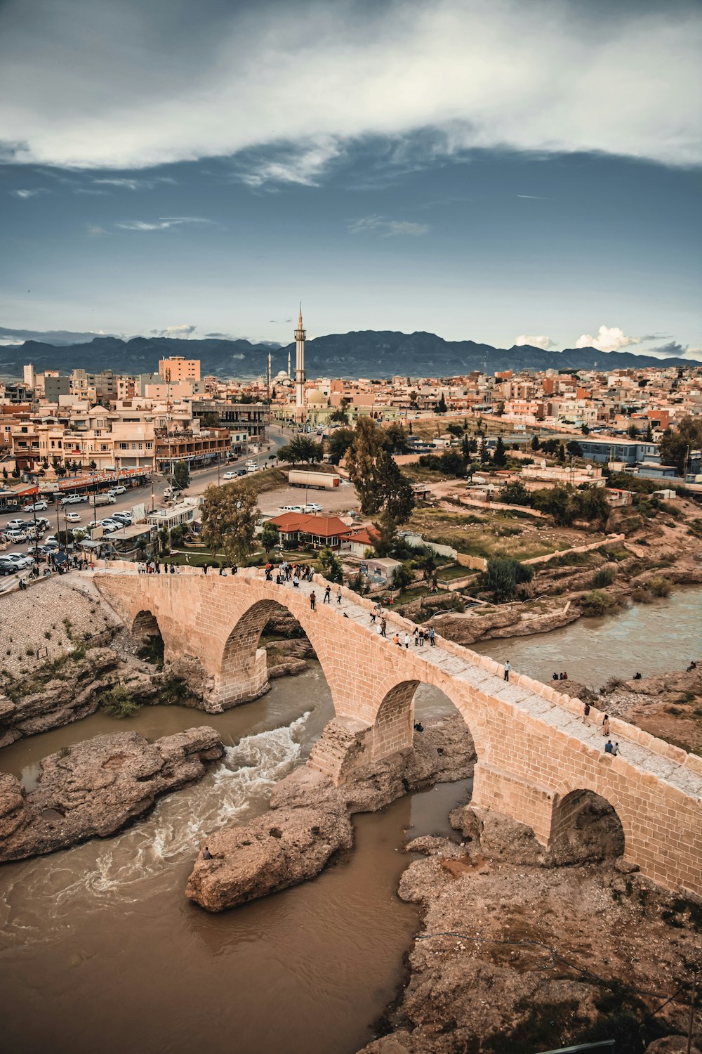 a bridge over a river with a city in the background