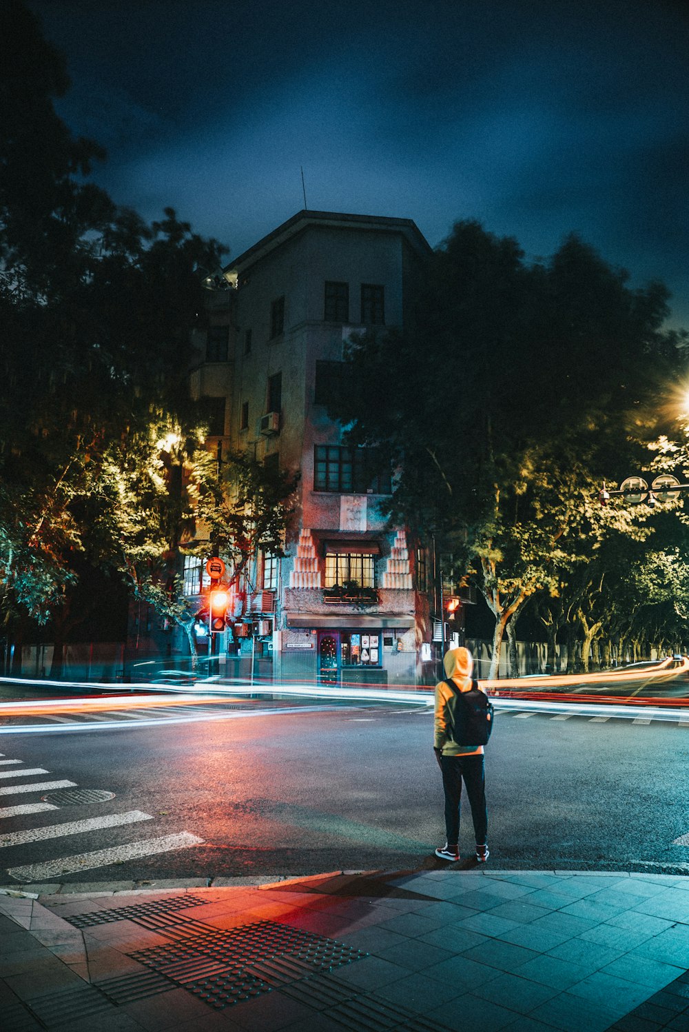 a person standing on a street corner at night