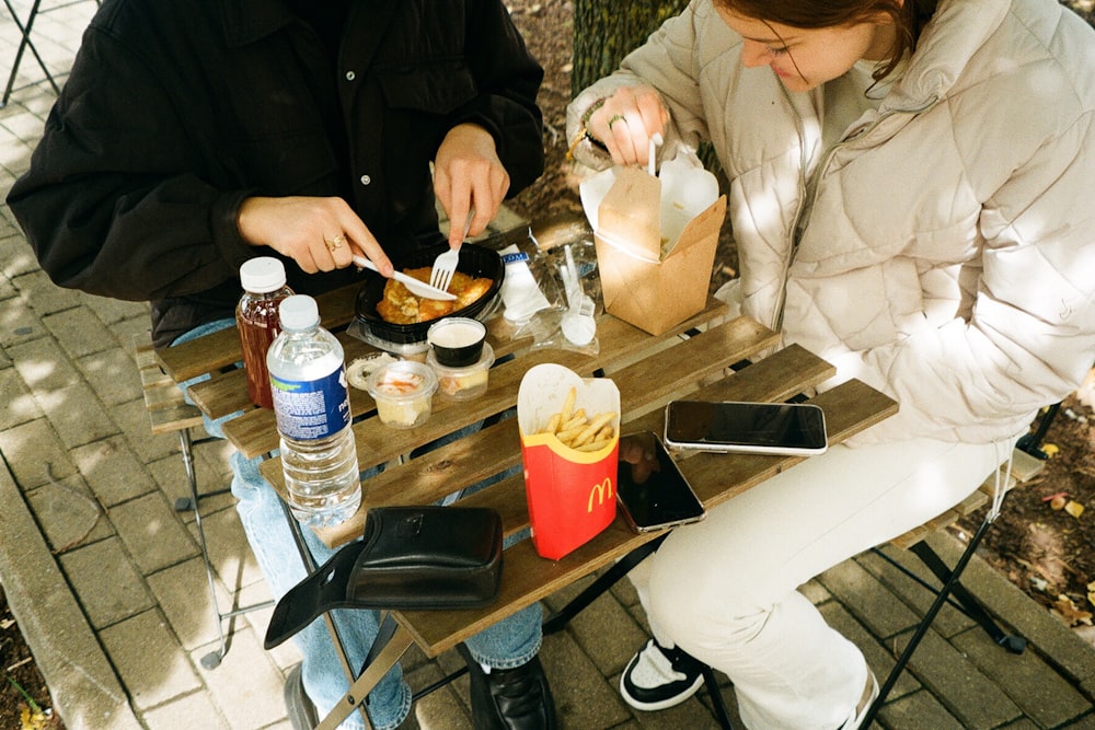 a man and a woman sitting at a table eating food