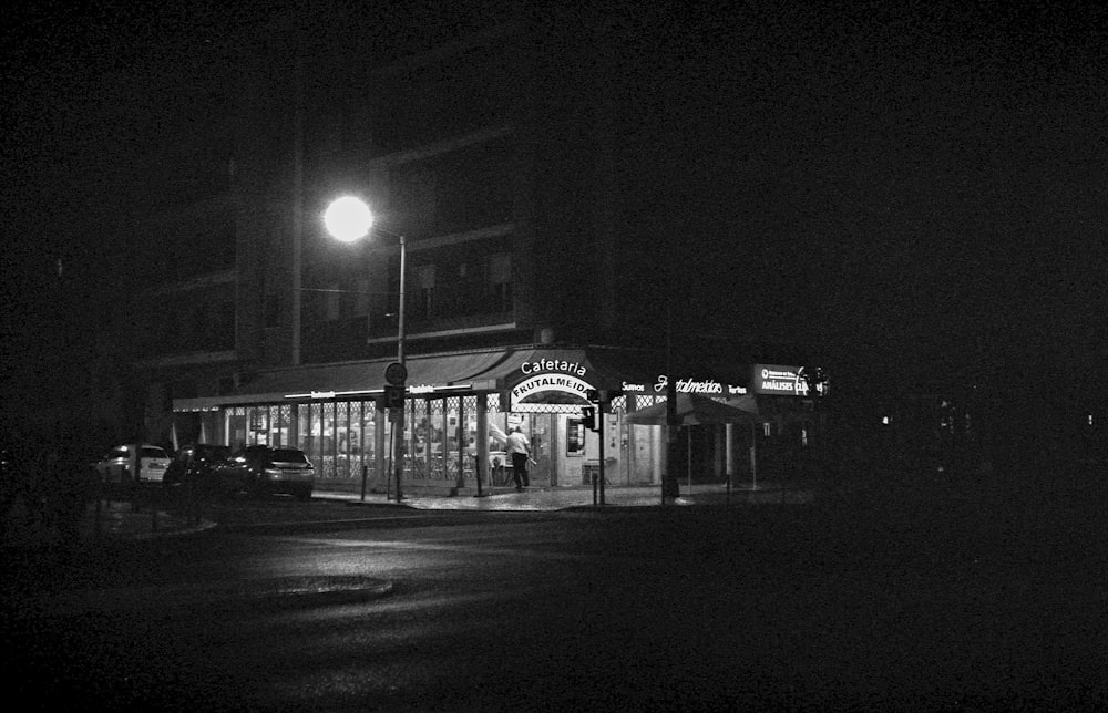 a black and white photo of a store at night