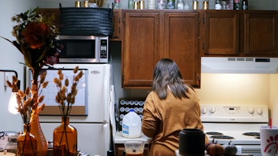 a woman standing in a kitchen next to a stove top oven