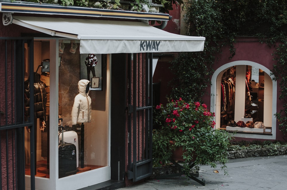 a store front with a white awning and a white teddy bear