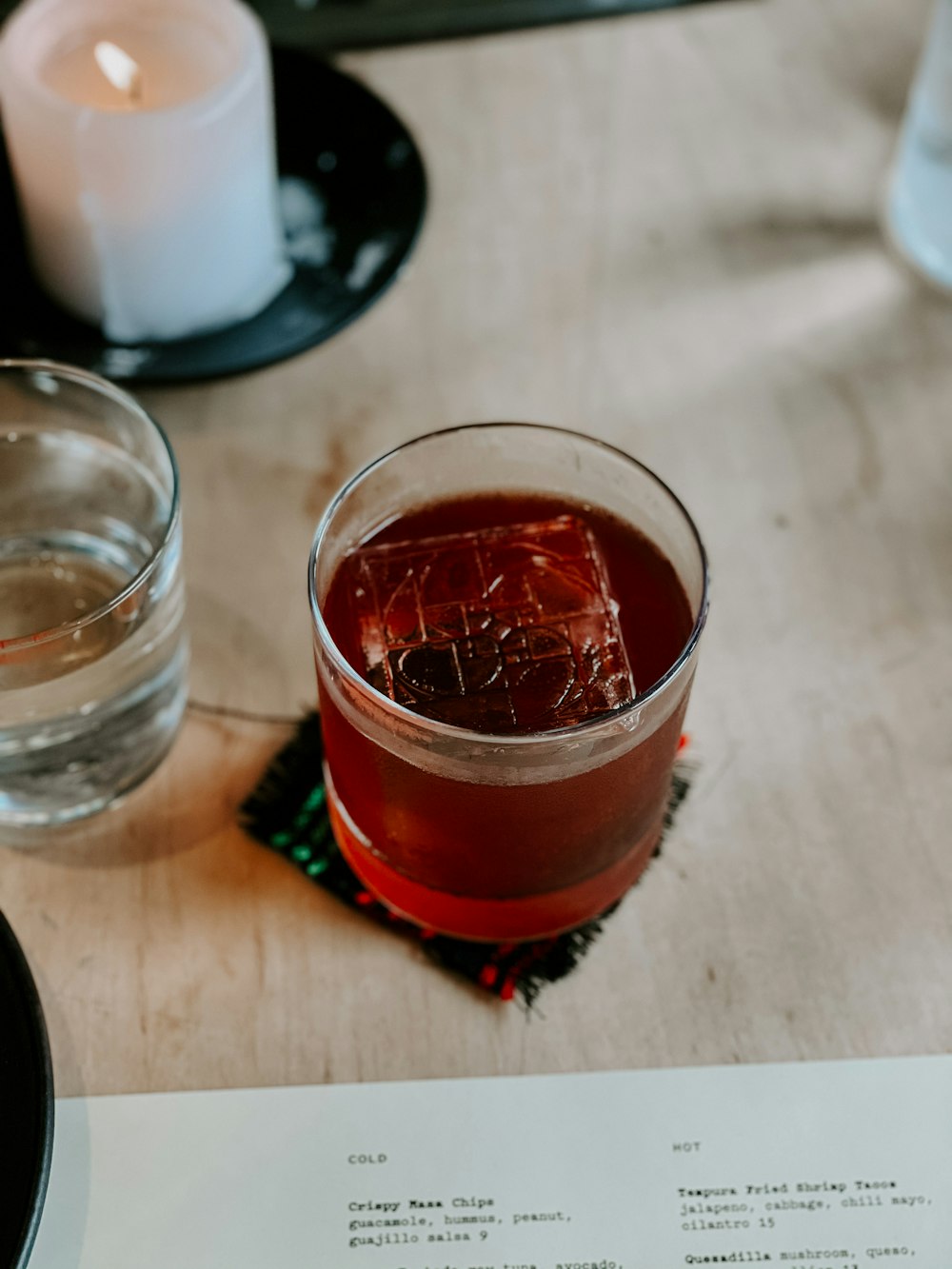 a glass of alcohol sitting on top of a wooden table