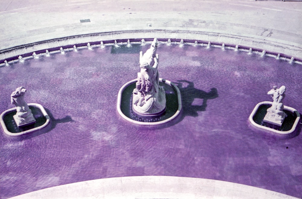 a statue of a woman sitting on top of a fountain