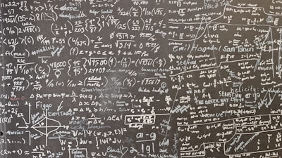 A chalkboard filled with neatly written LaTeX equations and diagrams.