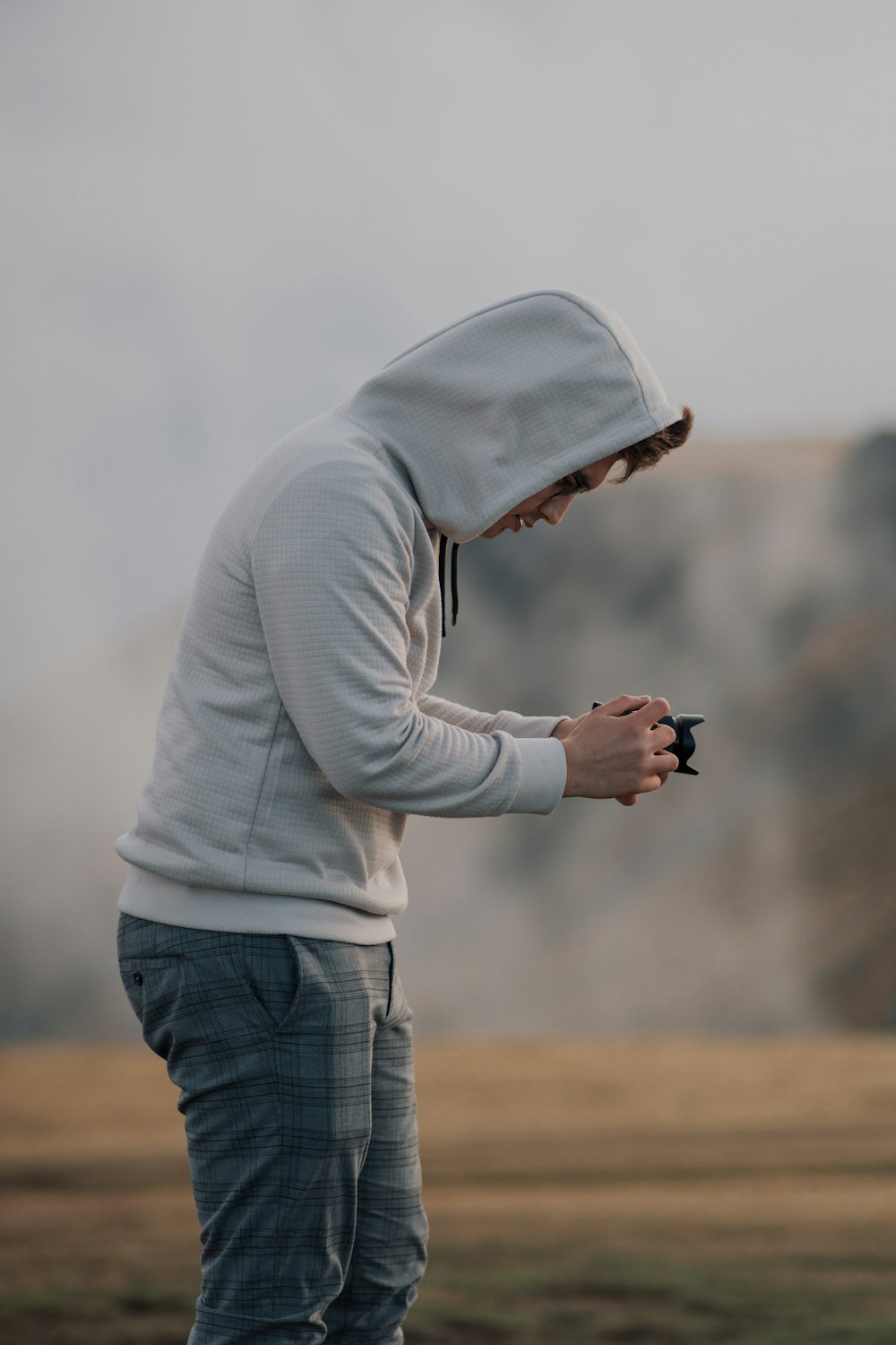 a man in a hoodie holding a cell phone