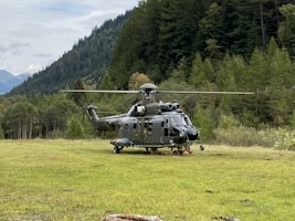 a helicopter sitting on top of a lush green field