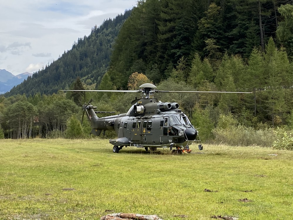 a helicopter sitting on top of a lush green field