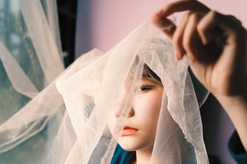 a young girl with a veil over her head