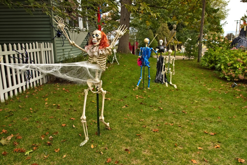 a yard decorated for halloween with skeletons and spider webs