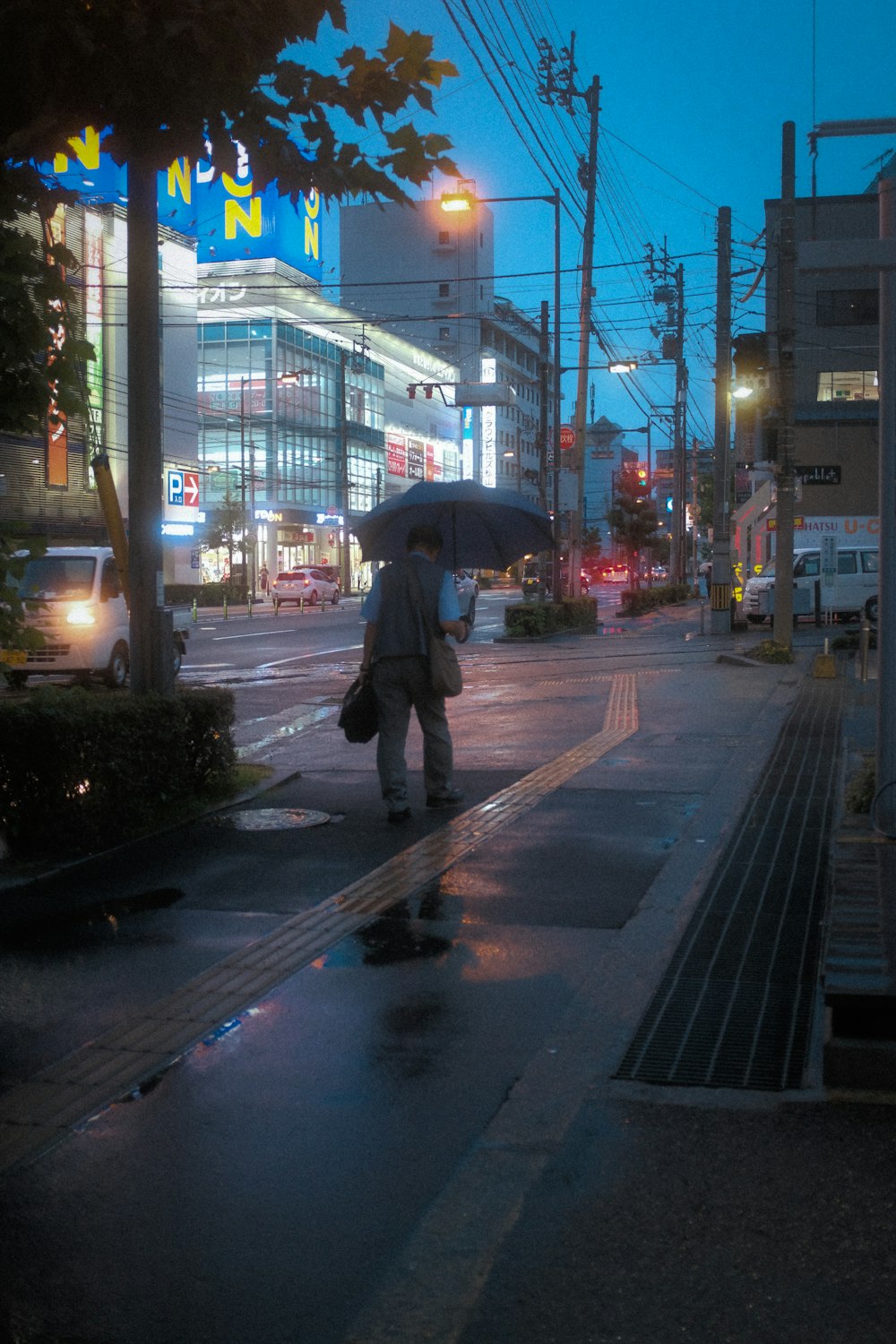 a man walking down a street holding an umbrella