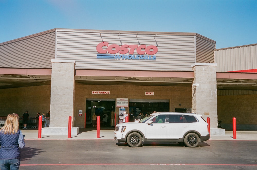 Une voiture blanche garée devant un magasin Costco