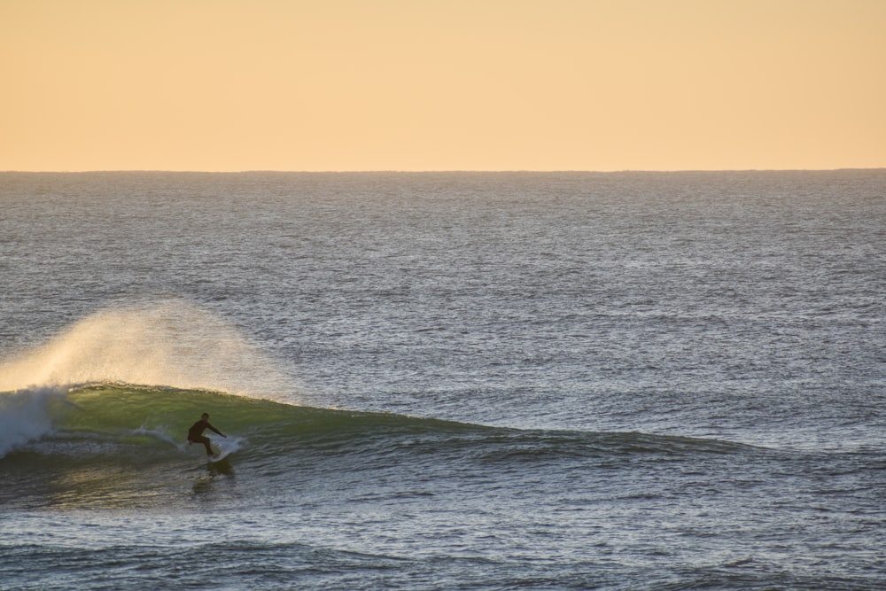 a person riding a wave on top of a surfboard