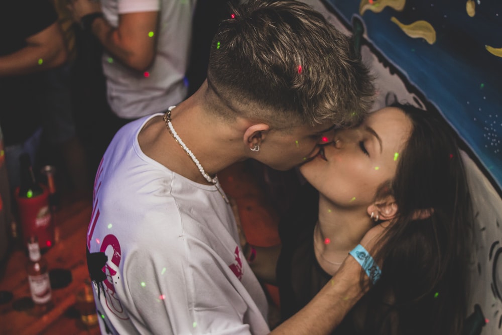 a man and a woman kissing in front of confetti