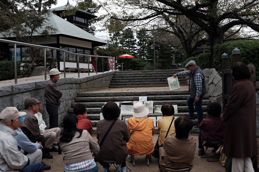 a group of people sitting in front of a stone wall