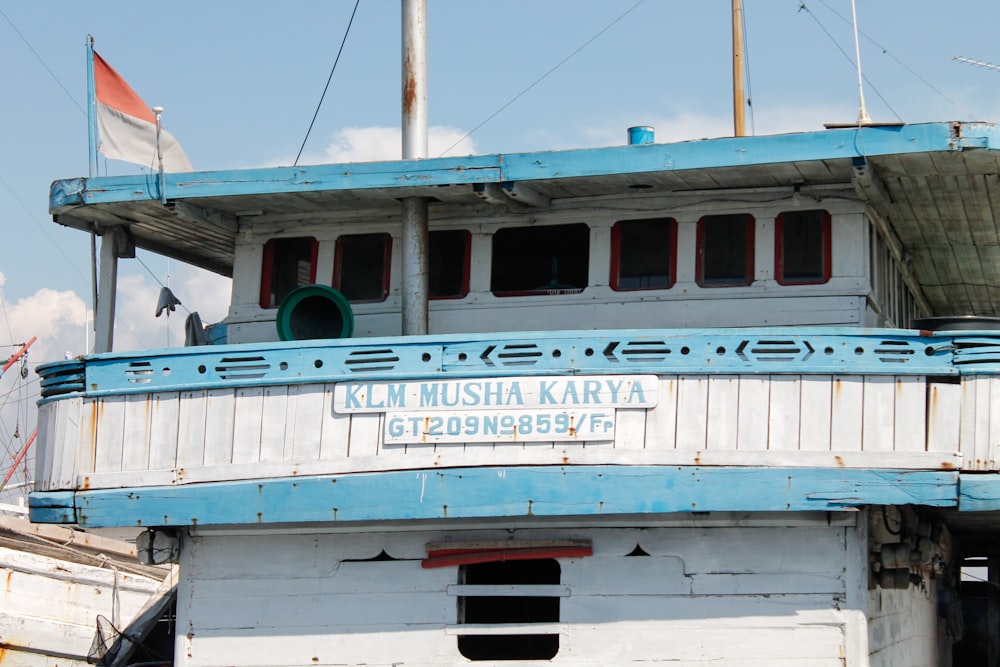 a blue and white boat sitting on top of a body of water