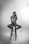 a black and white photo of a woman sitting on a stool