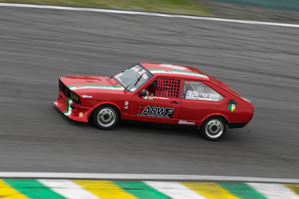 a red car driving down a race track