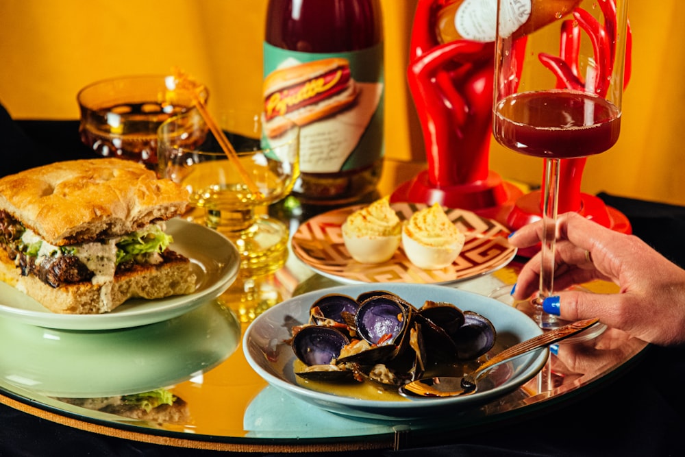 a table topped with plates of food and a glass of wine