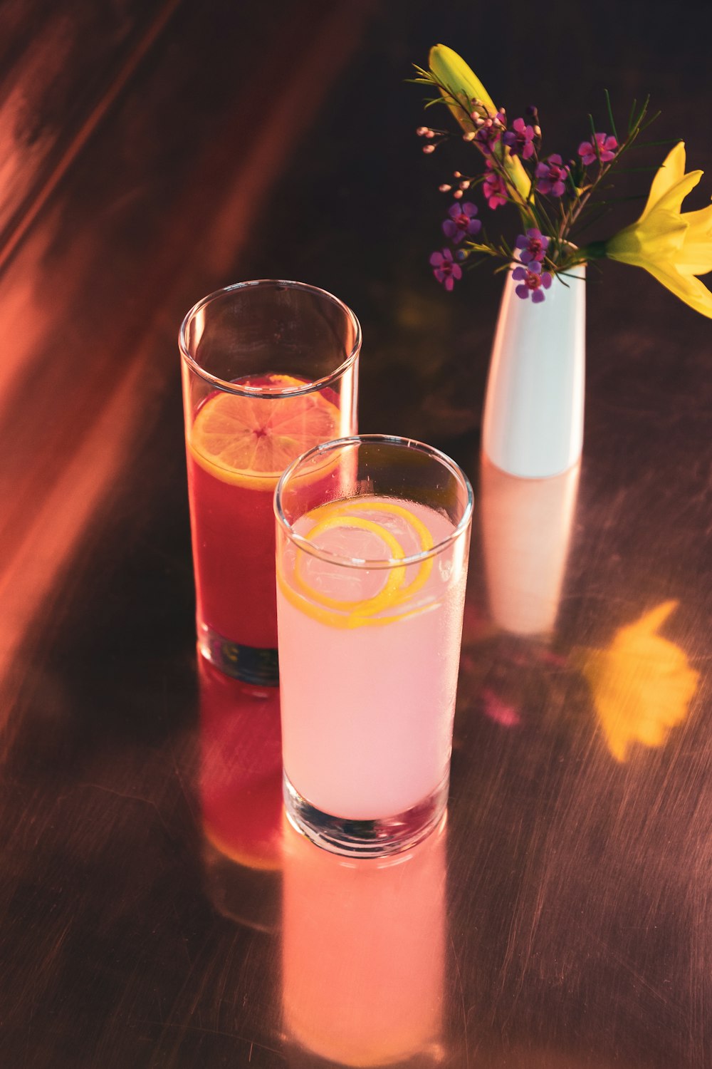 a couple of glasses filled with drinks on top of a table