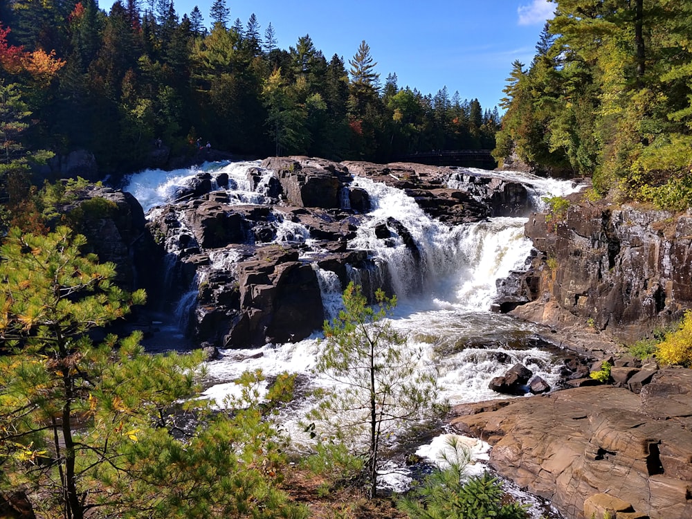 a large waterfall surrounded by trees and rocks