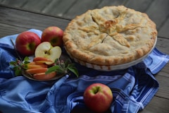 a pie and some apples on a table