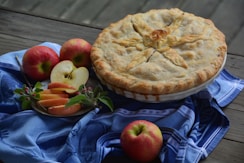 a pie and some apples on a table