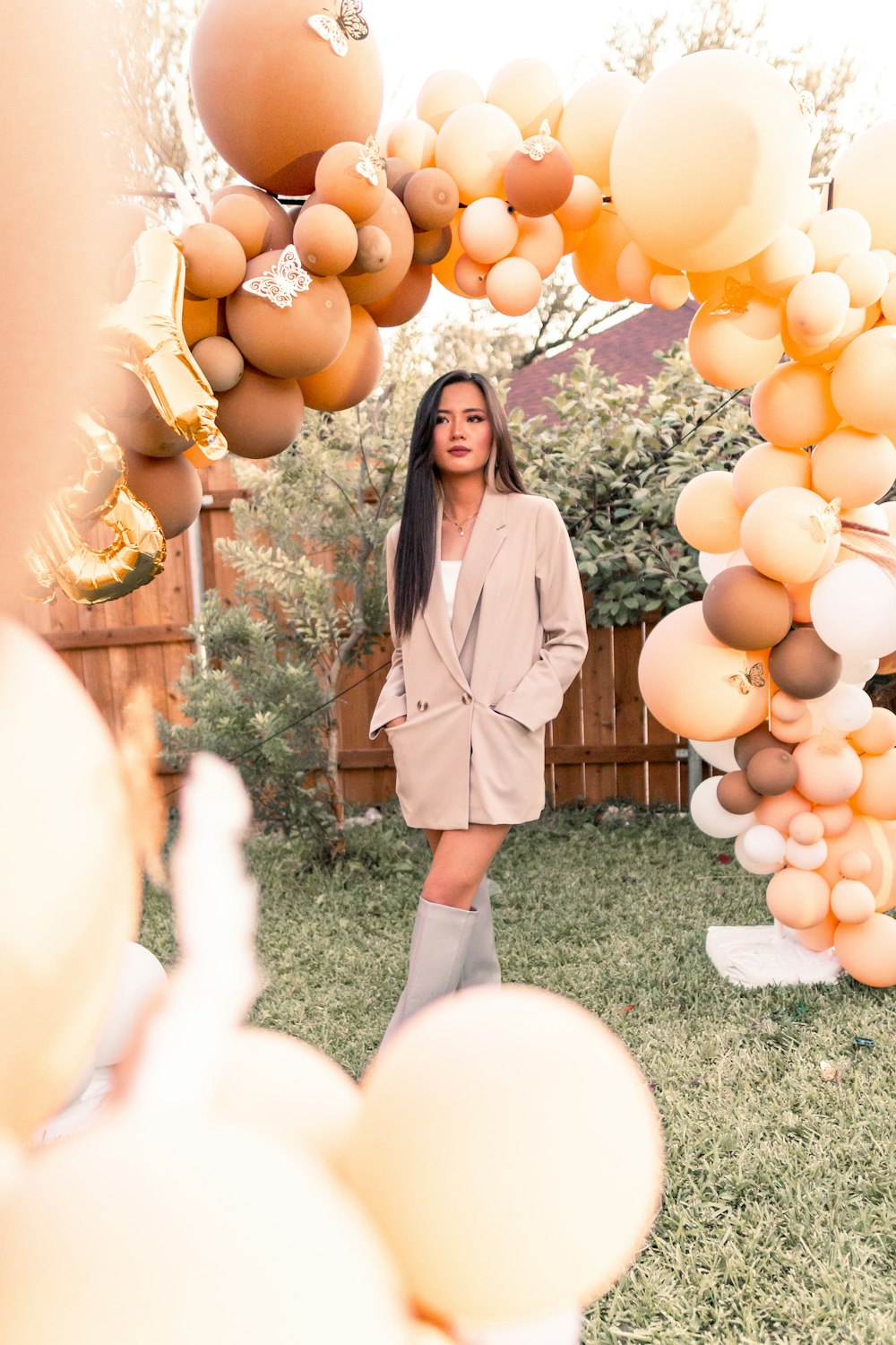 a woman standing under a bunch of balloons