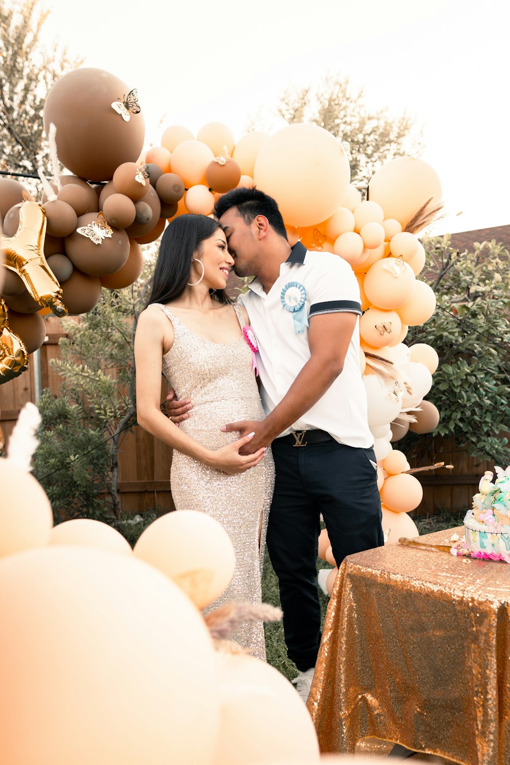 a pregnant couple standing in front of a cake