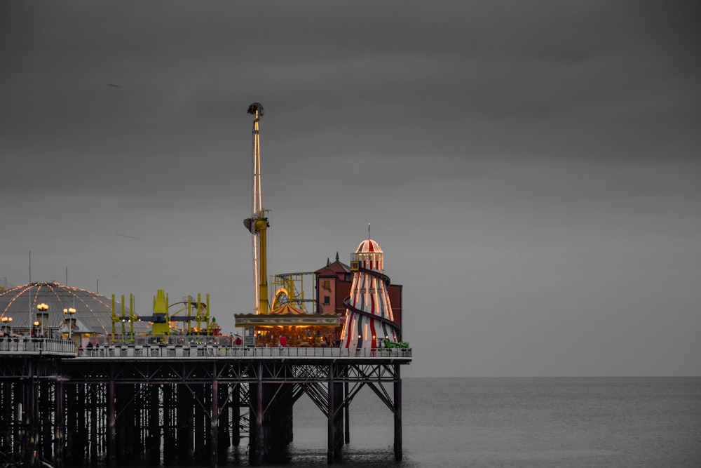 a pier with a ferris wheel and a ferris wheel in the distance