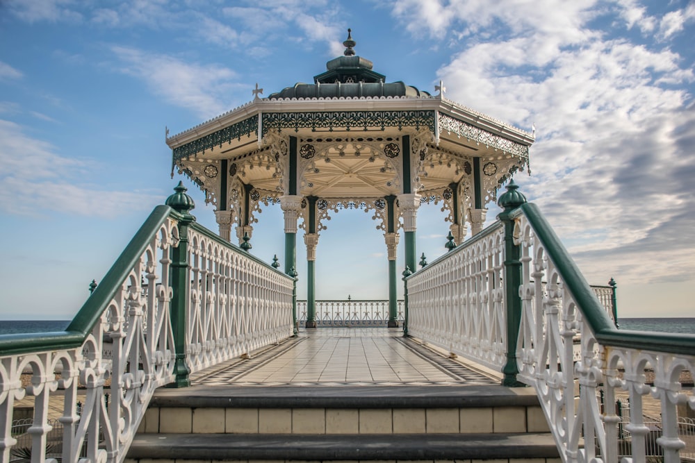 a white and green gazebo sitting on top of a pier