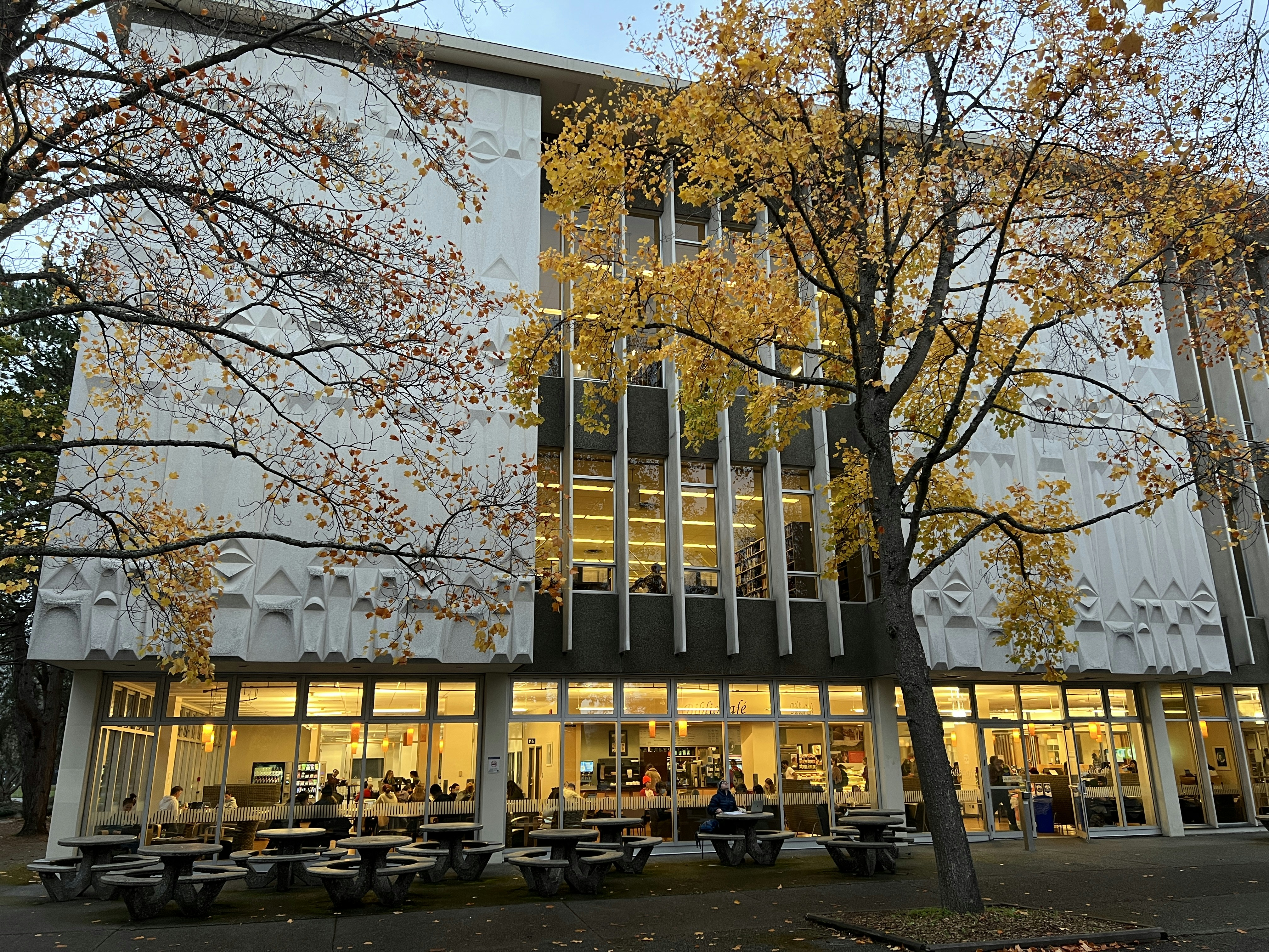 a building with a lot of tables and benches in front of it