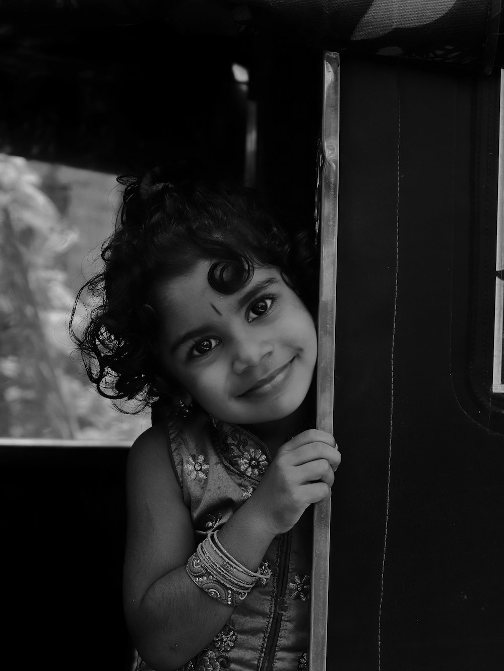 a little girl that is looking out of a window