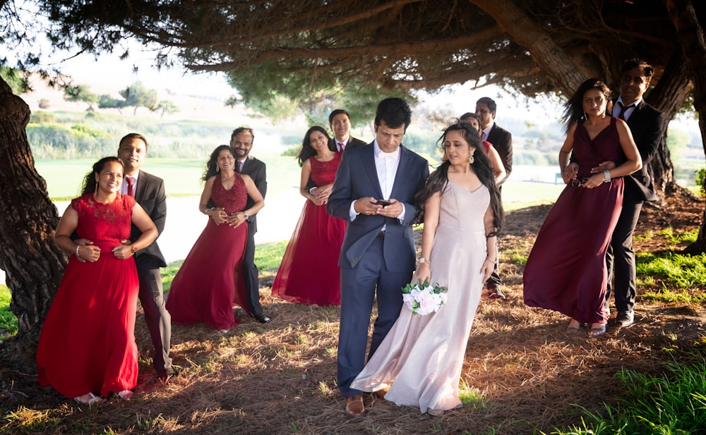 a group of people standing next to each other under a tree