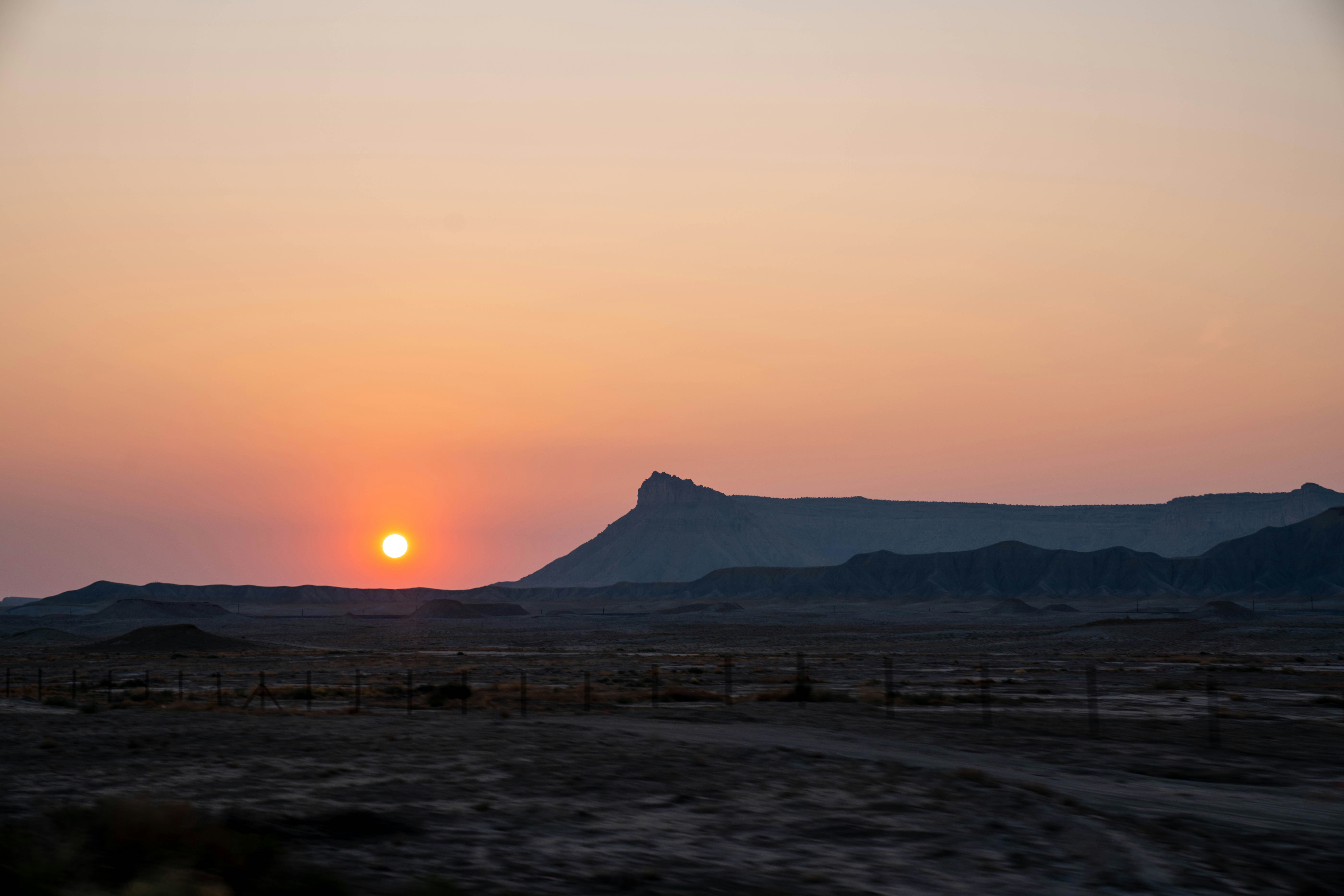 the sun is setting over the mountains in the desert