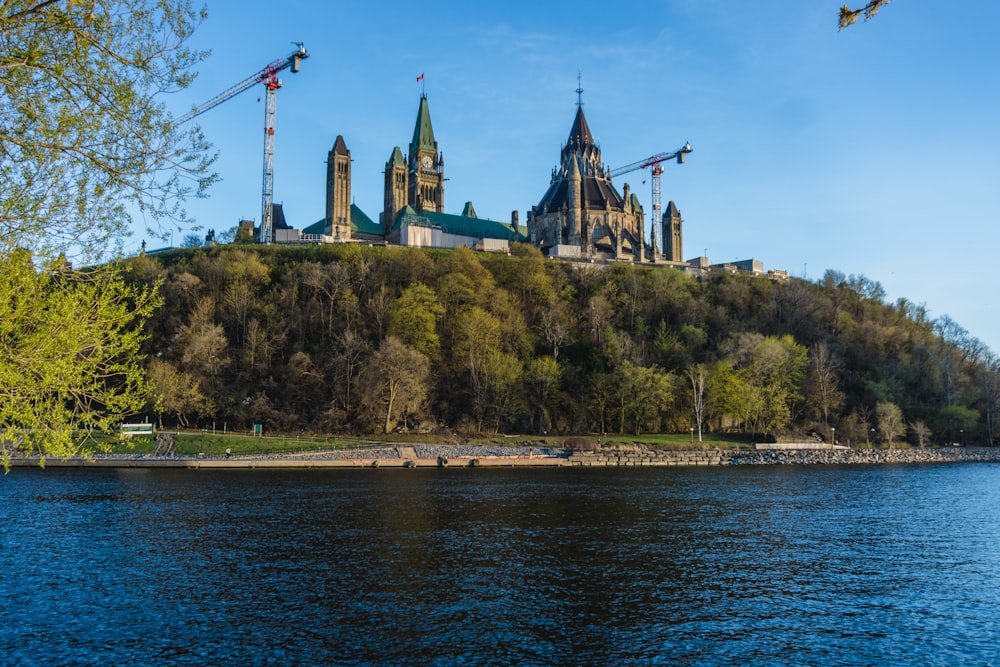 a large building sitting on top of a hill next to a body of water