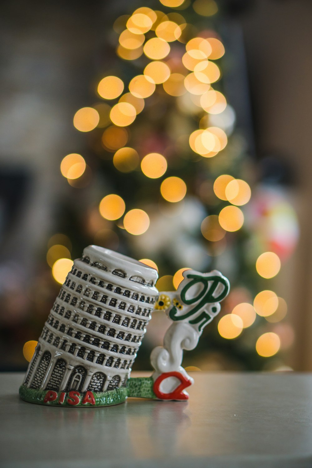 a close up of a small figurine near a christmas tree