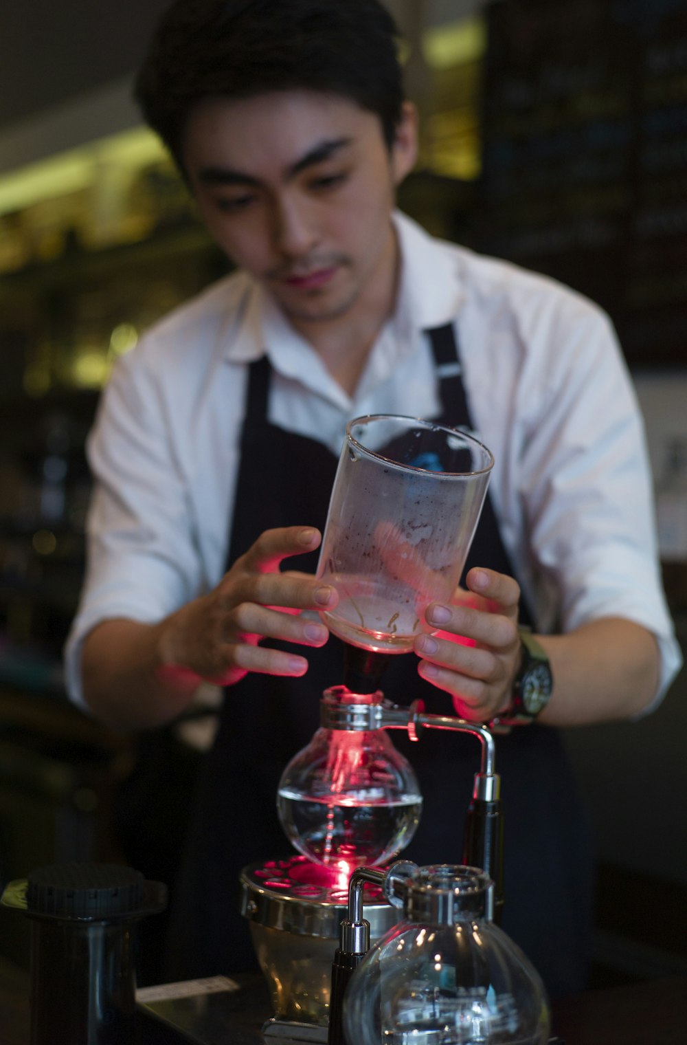 a man in an apron is holding a glass