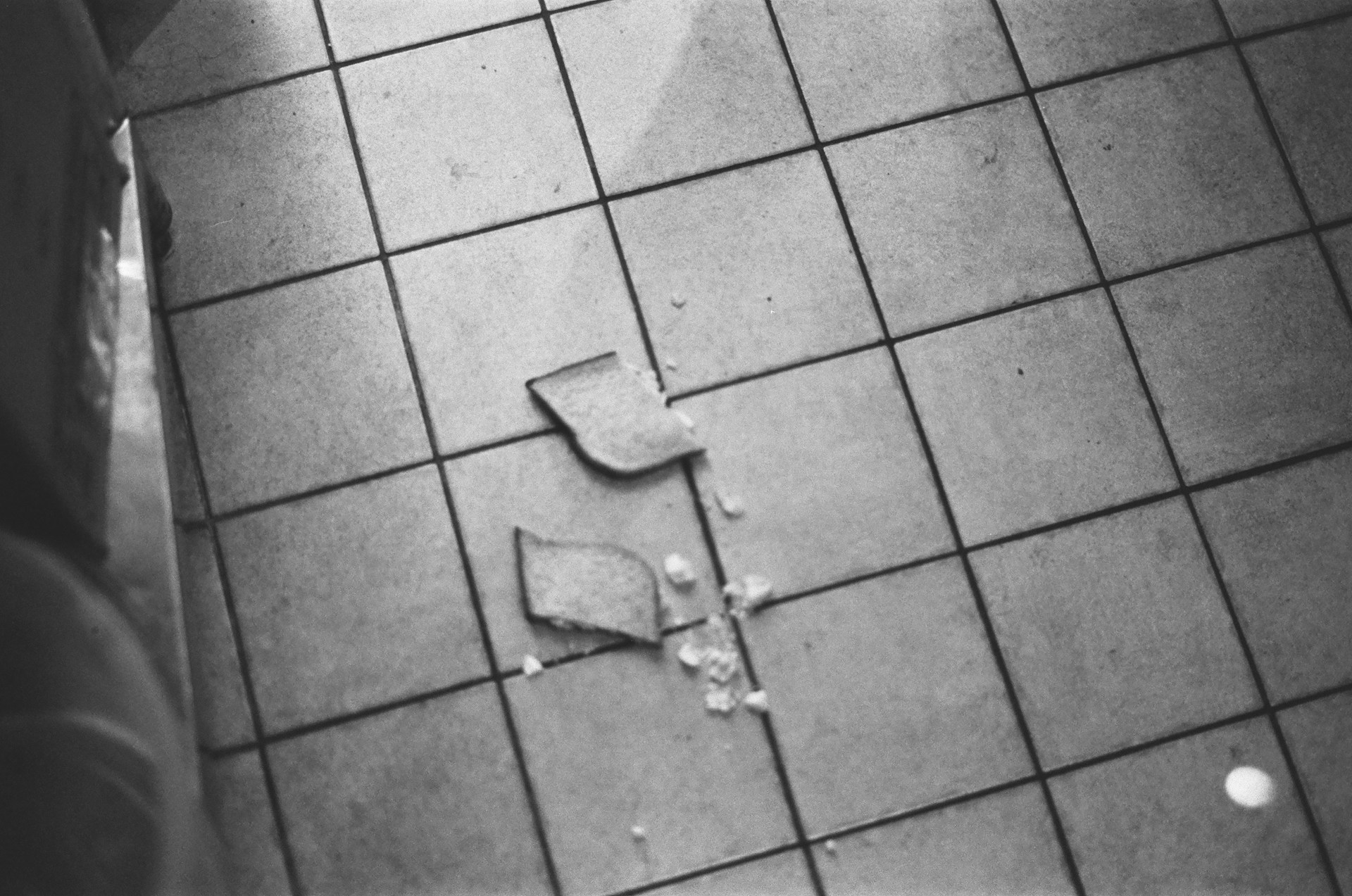 Before-and-after shot of a cracked tile floor transformed into a flawless, polished surface.